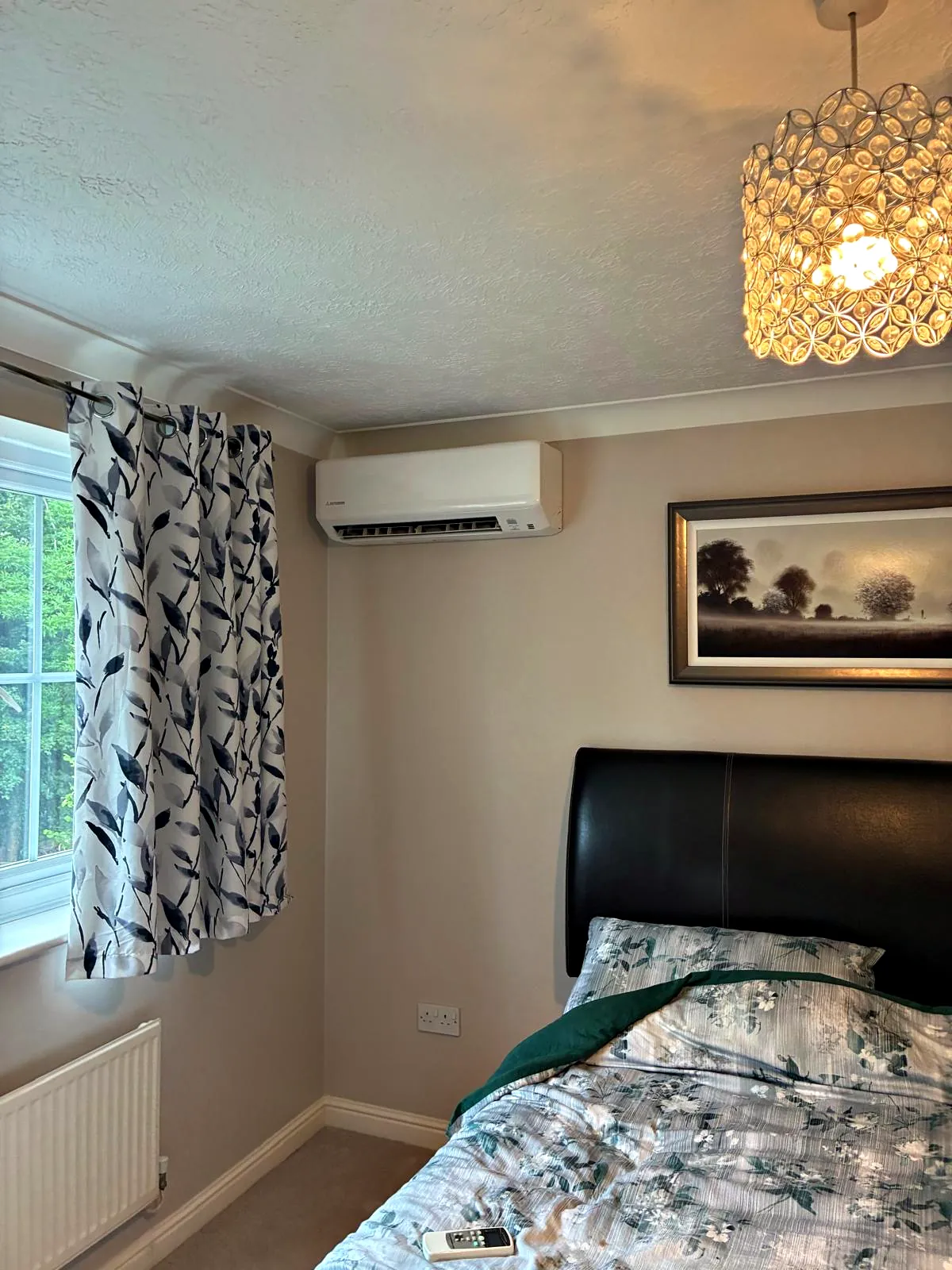 A Mitsubishi Heavy Industries wall mounted unit high on a bedroom wall beside the window