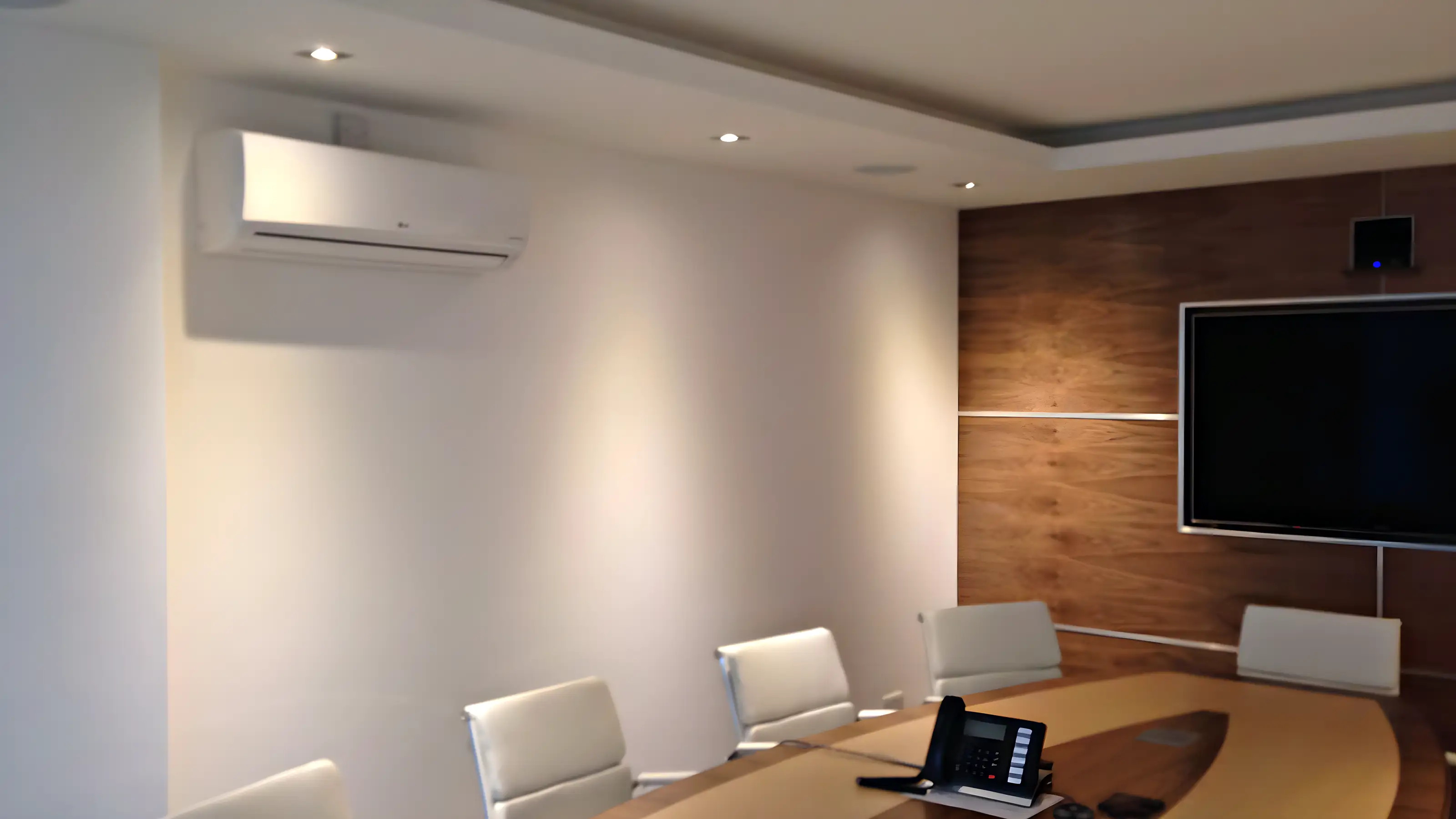 A wall mounted unit in a meeting room with a long table