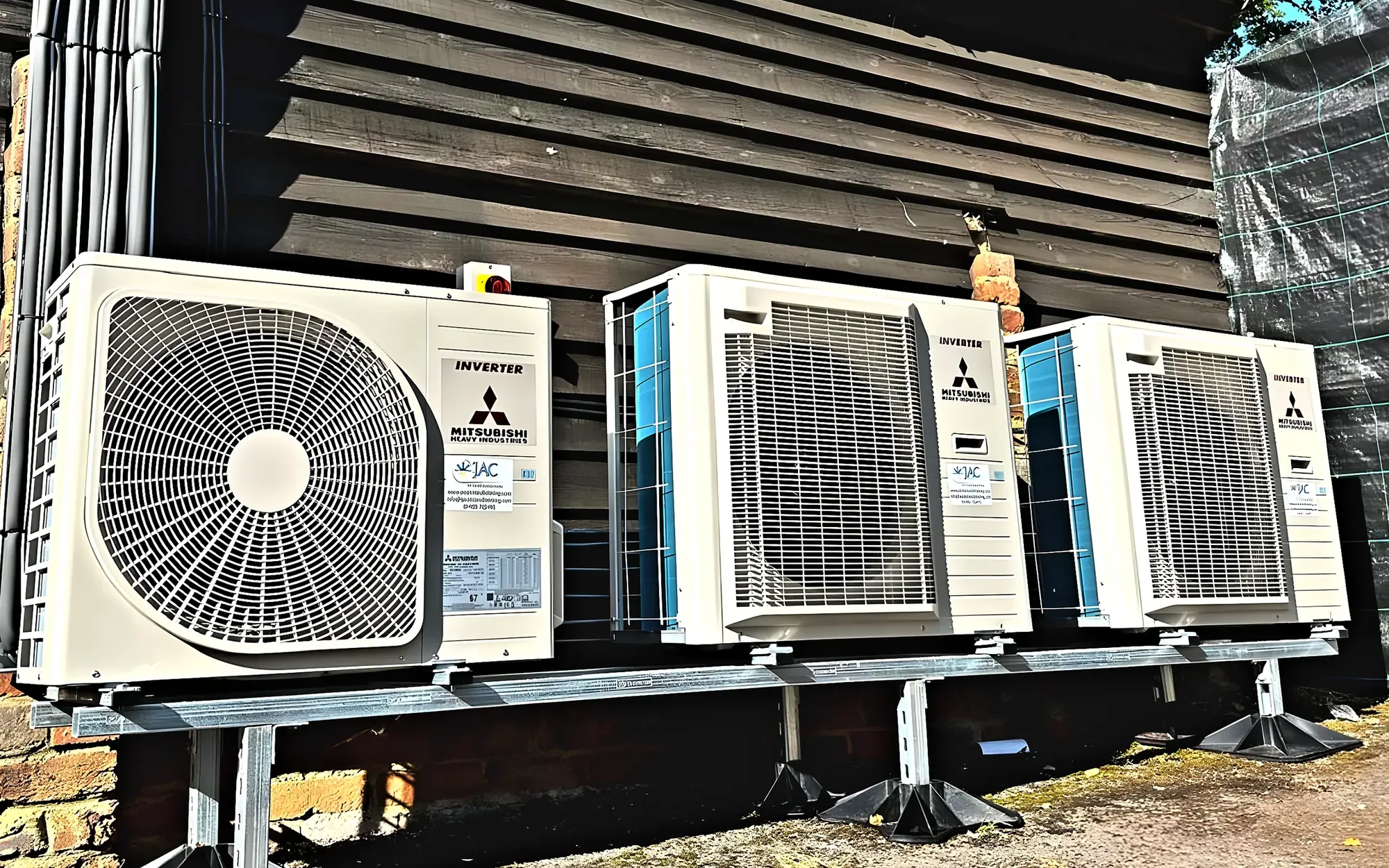 Three Mitsubishi Heavy Industries outdoor units on a steel stand against a timber wall