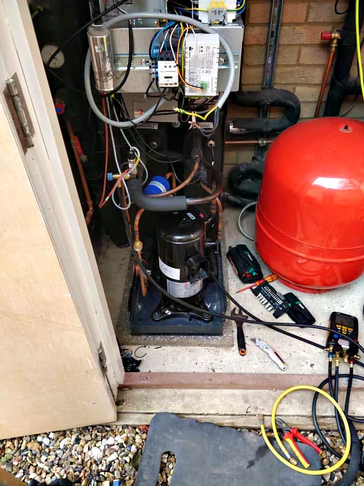 A compressor opened up on a repair with gauges and tools out
