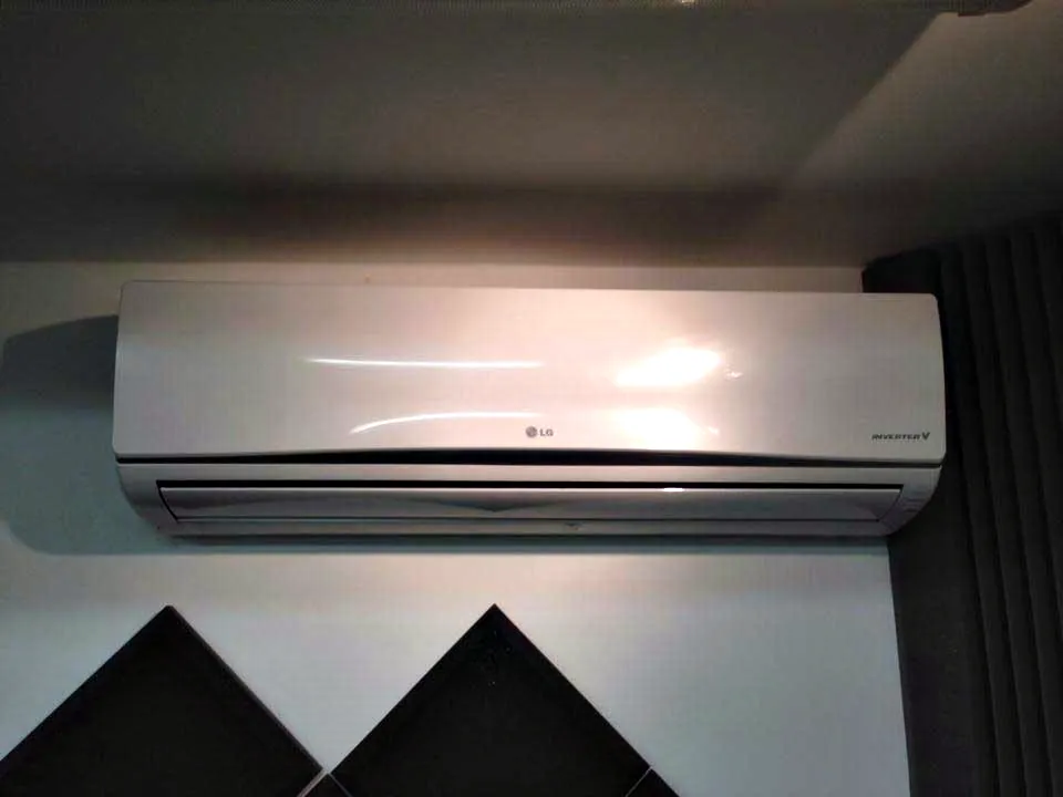A slim wall mounted indoor unit above a doorway in a white room
